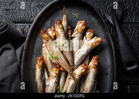 Salzige geräucherte Sprossen als beliebte mediterrane Küche. Geräucherter Fisch, mariniert mit Salz und Kräutern. Stockfoto