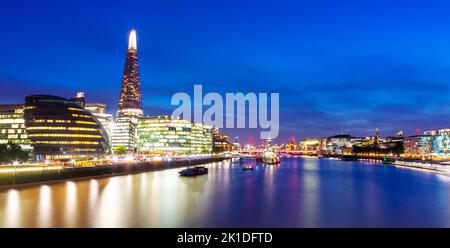 Panoramablick, Blick nach Südwesten, The Shard, HMS Belfast und andere Gebäude entlang der Londoner South Bank, beleuchtet gegen den inky blauen Sommerhimmel. Stockfoto