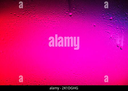 Textur in einem Glas mit Wassertropfen auf farbenfrohem Hintergrund. Stockfoto