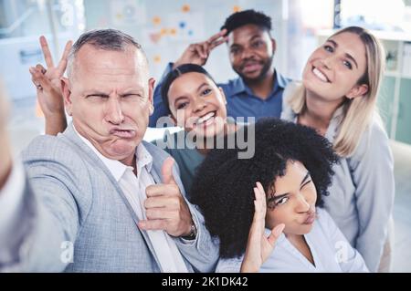 Kreatives, lustiges und geschäftliches Team, das gemeinsam ein Selfie macht, während man in einem Büro ist. Glückliche Mitarbeiter Freunde nehmen eine dumme, lustige und komische Arbeit Stockfoto