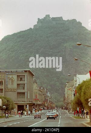 Deva, Rumänien, ca. 1976. Die 13. Jahrhundert Festung von Deva auf dem Berg scheinen von der Hauptstraße durch die Stadt, Str. 1 Decembrie (dann Bvd. Petru Groza). Stockfoto