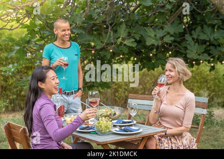 Gruppe von reifen glücklichen Freunden mit Wein zusammen in der Dinner-Party. Lächeln, Heiterkeit Konzept. Stockfoto