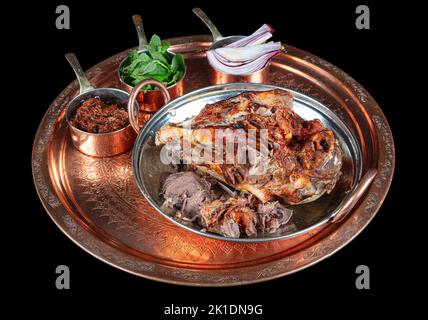 Braten Kopf eines Lammes. Traditionelles türkisches Offalgericht Kelle Sogus, Lammkopffleisch mit Brain Servierportion auf einem Kupferteller. Stockfoto