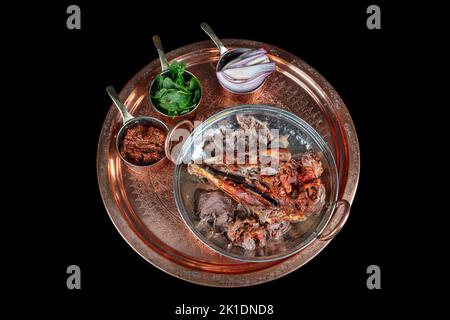 Braten Kopf eines Lammes. Traditionelles türkisches Offalgericht Kelle Sogus, Lammkopffleisch mit Brain Servierportion auf einem Kupferteller. Stockfoto