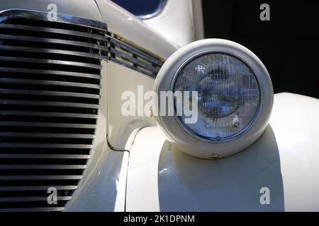 Monterey, CA, USA - 18. Aug 2022: Makroaufnahme von Scheinwerfer und Frontgrill einer cremefarbenen DeSoto-Limousine in makellosem Zustand. Wird während Clas angezeigt Stockfoto