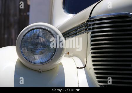 Monterey, CA, USA - 18. Aug 2022: Makroaufnahme von Scheinwerfer und Frontgrill einer cremefarbenen DeSoto-Limousine in makellosem Zustand. Wird während Clas angezeigt Stockfoto