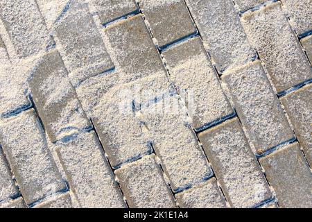 Verlegte Betonplatten sind mit leichtem Sand bedeckt, um die Fugen zu füllen, selektiver Fokus Stockfoto