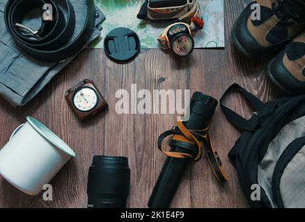 Flaches Lay von Campingausrüstung auf einem hölzernen Hintergrund Stockfoto
