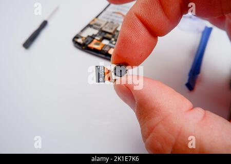 Eine Smartphone-Werkstatt hält ein Modell von einem Smartphone in den Händen. Stockfoto