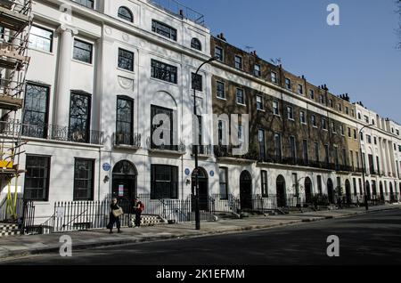 London, Großbritannien - 21. März 2022: Fußgänger genießen die Sonne auf dem historischen Meckenburgh Square in Bloomsbury im Zentrum von London. Die blauen Plaketten an Stockfoto