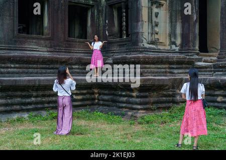 Kambodscha. Provinz Siem Reap. Junge Mädchen, die sich vor dem Tempelriff in Angkor Wat (Tempelstadt) fotografieren Stockfoto