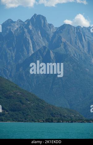 Eine vertikale Aufnahme der Berge rund um den Comer See unter an einem sonnigen Tag in der Region Lombardei, Italien Stockfoto