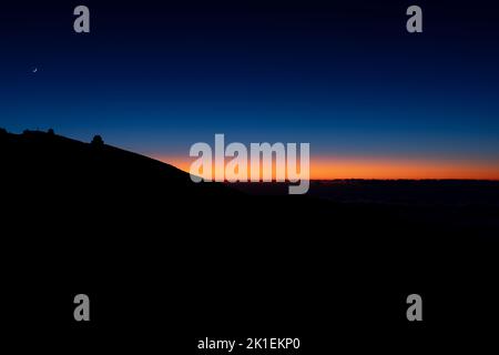 Aufgehender Mond und astronomisches Observatorium über dem Berg bei Sonnenuntergang Stockfoto