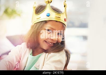 Es ist nicht einfach, eine Prinzessin zu sein. Ein niedliches kleines Mädchen, das zu Hause als Prinzessin verkleidet ist. Stockfoto