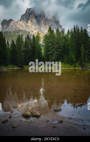 Erstaunlicher kleiner See im grünen Wald und spektakuläre neblige Berge im Hintergrund, Lago Bai de Dones See, Dolomiten, Italien, Europa Stockfoto