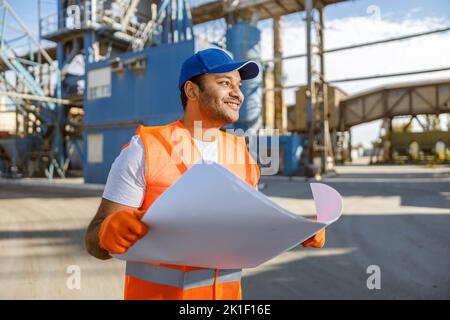 Erfahrener Arbeiter, der vor einem großen Werk steht Stockfoto