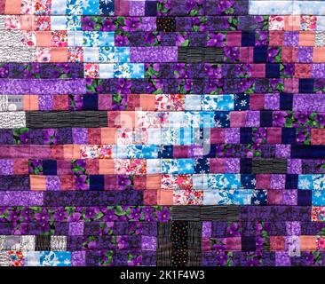 Patchwork-Steppdecke. Teil von Patchwork-Quilt als Hintergrund. Blumendruck. Farbdecke im Stil Patchwork. Farbdecke. Handgefertigt Stockfoto