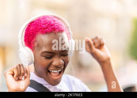 Afrikanische Frau tanzt, während sie draußen Musik hört Stockfoto