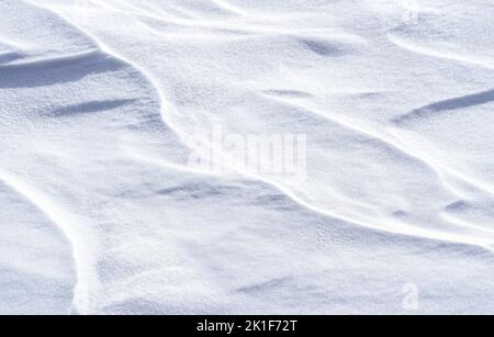 Frisch gefallener Schnee sieht aus wie vom Wind geformte Dünen. Winter abstrakt Schnee Textur Hintergrund. Stockfoto