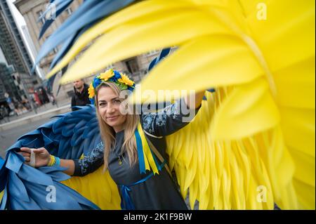 18. September 2022, Hessen, Frankfurt/Main: Alla aus Lemberg steht mit Engelsflügeln in den Farben der Ukraine auf dem Opernplatz während einer Demonstration zur Unterstützung der Ukraine. Es ist eine Gegendemonstration zu einer pro-russischen Demonstration auf dem Opernplatz. Foto: Sebastian Gollnow/dpa Stockfoto