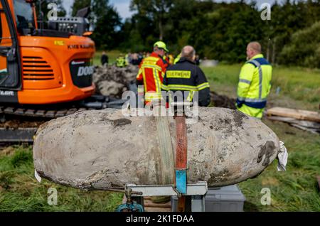 Schwentinental, Deutschland. 18. September 2022. Mitarbeiter des Sprengstoffentsorgungsdienstes Schleswig-Holstein sowie Polizei und Feuerwehr stehen hinter einer entschärften Luftbombe des Zweiten Weltkriegs. Während der Erkundungsarbeiten trafen Mitarbeiter des Sprengstoffentsorgungsdienstes auf drei Luftbomben, die entschärft werden konnten. Quelle: Axel Heimken/dpa/Alamy Live News Stockfoto