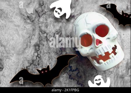 Halloween Totenkopf und Dekorationen auf grauem Hintergrund. Flach lagen Fledermäuse und Schädel. Halloween Grußkarte Stockfoto
