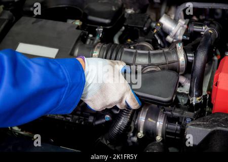 Nahaufnahme Hände des Menschen ist Mechaniker Reparatur Motor des Autos in der Garage, Autoservice, Arbeiter beheben und Einstellen Teil des Automobils mit Problemen in der Stockfoto