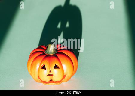 Jack-O-Laterne mit starkem Schatten auf blauem Hintergrund. Halloween-Konzept. Stockfoto