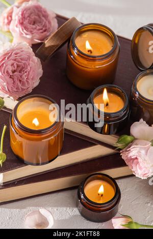 Ein Set verschiedener Duftkerzen in braunen Glasgefäßen. Handgemachte Duftkerze. Sojalkerzen brennen in einem Glas. Aromatherapie und entspannen Sie sich im Spa und zu Hause. Feuer in braunem Glas. Stockfoto