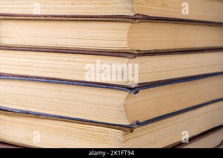 Buchhintergrund. Stapel von Büchern in der Bibliothek. Alte gelbe Seiten von Papierbüchern. Lernen und Wissen. Stockfoto