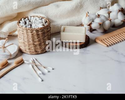 Zero Waste persönliche Bad-Accessoires. Holzkamm, Seife, Zahnbürste, Baumwolltuch auf Marmorboden. Kostenloses Kunststoffkonzept. Umweltfreundliches Haus Ca Stockfoto