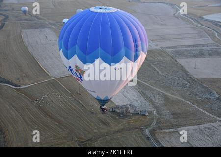 Ein Heißluftballon über den Sandsteinfelsen in Kappadokien, in der Nähe von Goreme in der Türkei Stockfoto