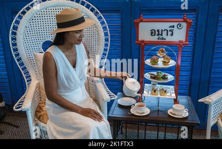 Asiatische Frauen, die einen luxuriösen High Tea mit Snacks und Tee in einem Luxushotel genießen Stockfoto