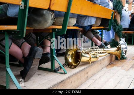 München, Deutschland. 18. September 2022. Mitglieder einer Trachtengruppe feiern im Festzelt nach der Tracht- und Schießprozession auf dem Oktoberfest, nachdem sie ihre Instrumente abgenommen haben. Quelle: Sven Hoppe/dpa/Alamy Live News Stockfoto