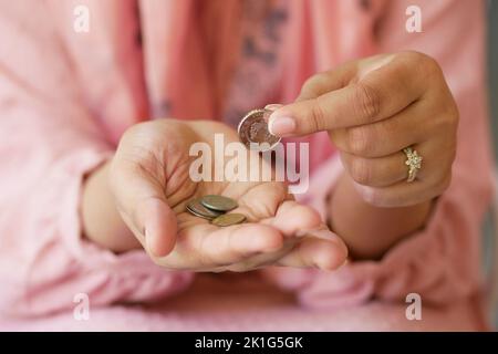 Nahaufnahme einer jungen Frau, die Münzen zählt Stockfoto