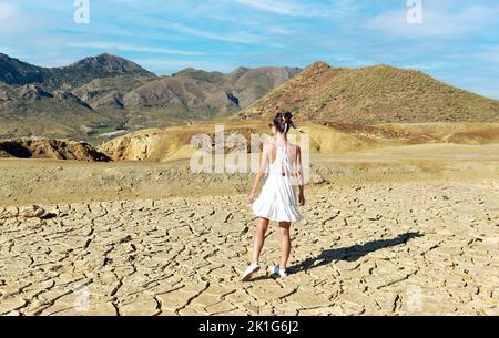 Rückansicht Junge weibliche Touristen in weißem Kleid besuchen alte verlassene Minen von Mazarron in Murcia auf blauem Himmel Hintergrund während sonnigen Sommertages. Reise d Stockfoto