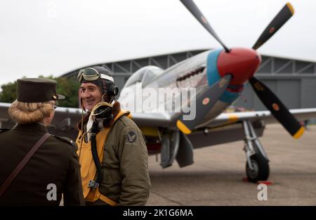 Reenactment actorsposing mit dem P-51D Mustang 'Tall in the Saddle' (G-SIJJ) vor seiner Flugausstellung auf der IWM Duxford Battle of Britain Airshow 1 Stockfoto