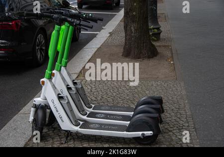 Berlin, Deutschland 28. Juni 2022, drei Lime Elektro-Scooter auf einem Bürgersteig Stockfoto