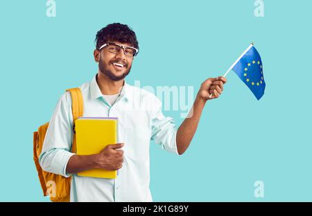 Positive indische man Student University mit Rucksack und Lehrbüchern winkende Flagge der Europäischen Union Stockfoto