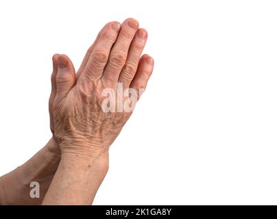 Die Hände einer älteren Frau sind in Gebetsnähe auf weißem Hintergrund gefaltet. Stockfoto