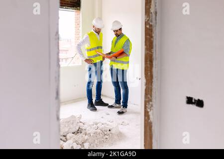 Zwei junge Architekten arbeiten auf der Baustelle zusammen Stockfoto