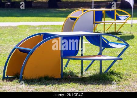 Farbenfroher Kinderspielplatz mit Metallgeländern im grünen Gras Stockfoto