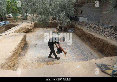 Gaza, Palästina. 18. September 2022. Ein palästinensischer Bauer reinigt einen Mosaikboden, der auf seiner Farm entdeckt wurde und laut offiziellen Angaben aus der byzantinischen Zeit im zentralen Gazastreifen stammt. Das palästinensische Ministerium für Tourismus und Antiquitäten kündigte die Entdeckung des Mosaiks an, das geschützt werden soll, und ein Ausgrabungsprojekt wird So bald wie möglich beginnen. (Foto von Ahmed Zakot/SOPA Images/Sipa USA) Quelle: SIPA USA/Alamy Live News Stockfoto