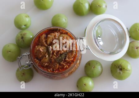 AMLA Pickle oder Stachelbeerpickel in einer Glasflasche gelagert. Es ist eine würzige Würze mit Amla, auch bekannt als indische Stachelbeeren, rotes Chilipulver Stockfoto