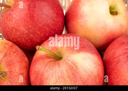 Mehrere saftige rote Äpfel in einem Korb, Makro. Stockfoto