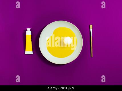 Künstlerisches Ei, mit gelbem Eiweiß und weißem Eigelb auf einem weißen Teller mit violettem Hintergrund. Minimalkonzept. Stockfoto