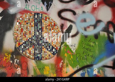 Nahaufnahme eines Graffiti- und Friedenszeichenmosaiks an der John-Lennon-Mauer in Prag, Tschechische Republik Stockfoto