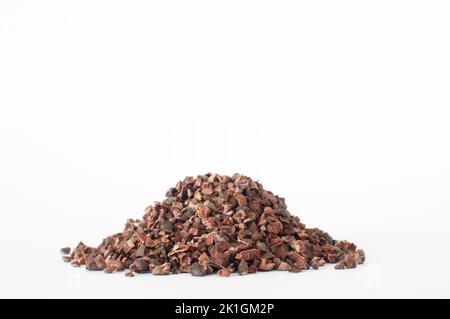 Haufen organischer roher Kakaospitzen, geringe Schärfentiefe im Vordergrund. Isoliert auf weißem Hintergrund. Stockfoto