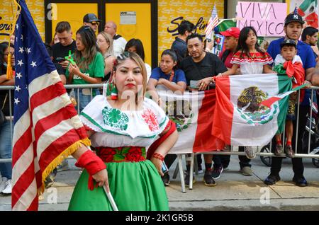 Der Teilnehmer der Parade trägt traditionelle mexikanische Kostüme und hält die US-Flagge während der jährlichen Parade zum Mexikanischen Tag entlang der Madison Avenue in New Yor Stockfoto