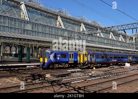 Ein Siemens-Zug der Baureihe 380 Desiro Electric und ein Super Sprinter-Dieselzug der Klasse 156 fahren vom Hauptbahnhof Glasgow, Schottland, Großbritannien ab Stockfoto